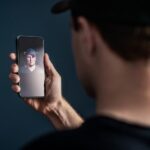 Person håller upp en mobil med ansiktsigenkänning för digital identifiering