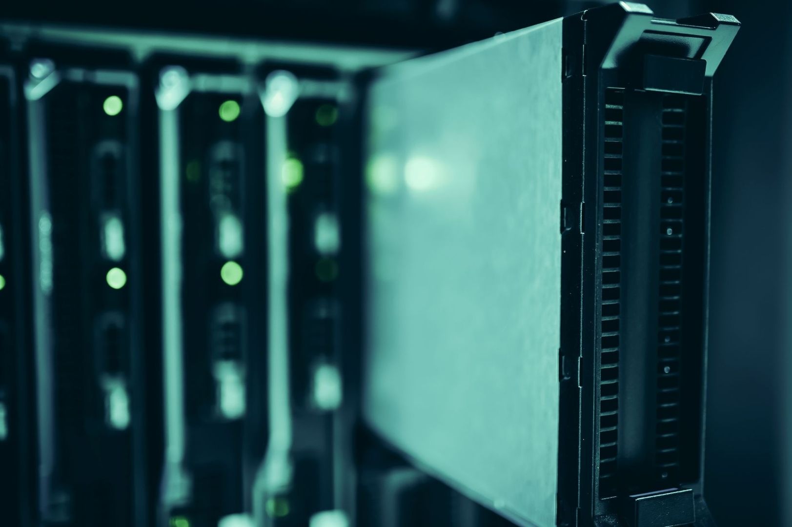 Närbild av serverutrustning med gröna indikatorlampor i mörkt datacenter